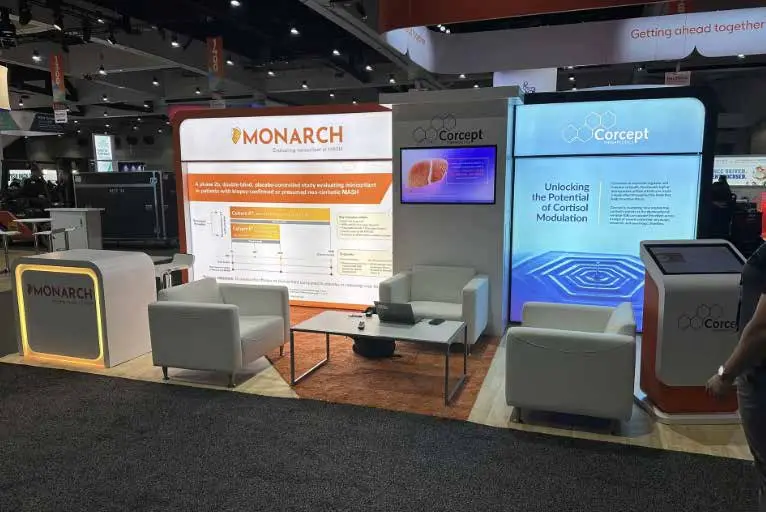 Trade show exhibit featuring MONARCH and Corcept branding, showcasing informational displays, seating area, and interactive technology, relevant to Elevate Exhibits trade show support services.