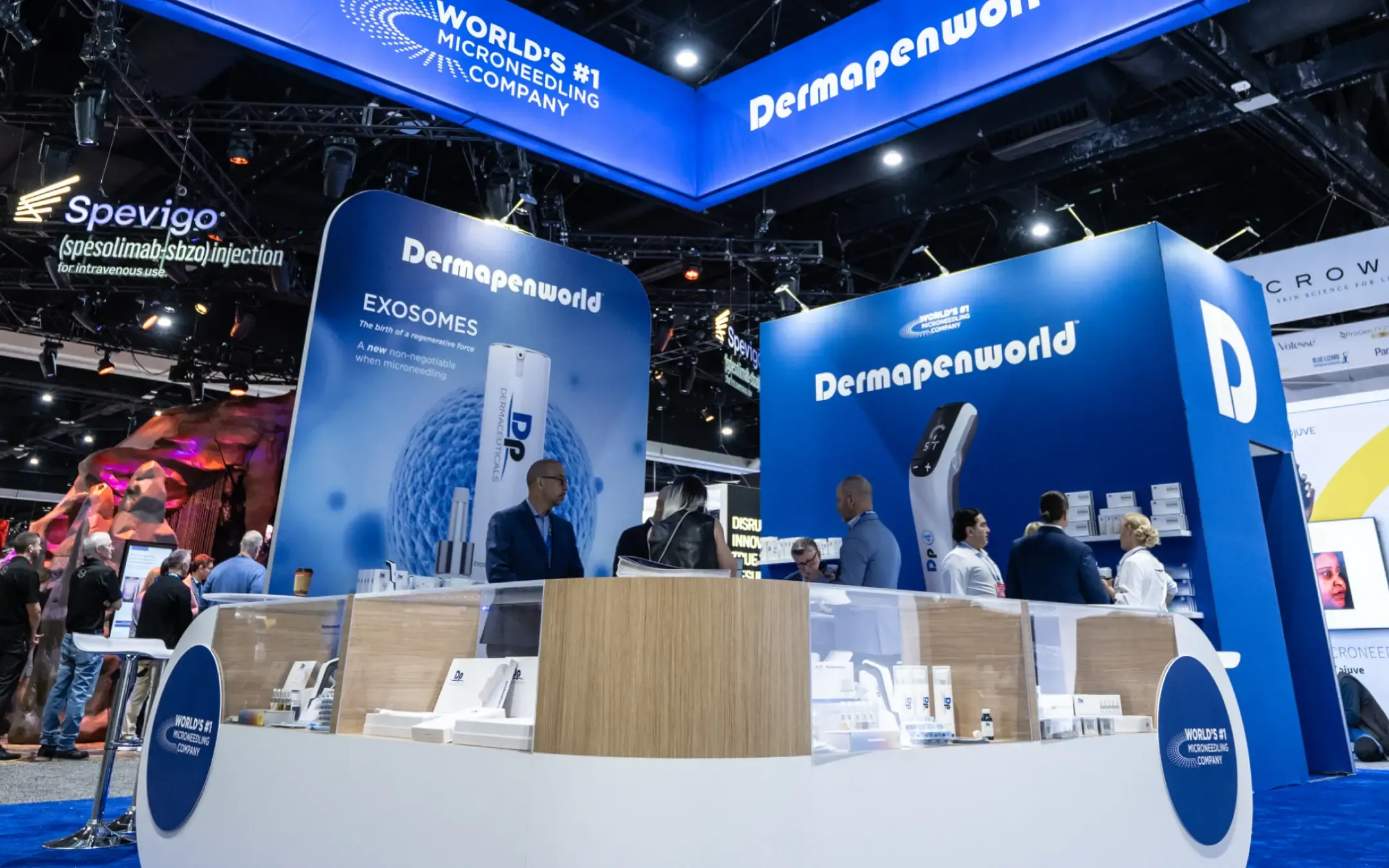 Trade show booth for Dermapenworld featuring branding, microneedling products, and professional representatives engaging with attendees.